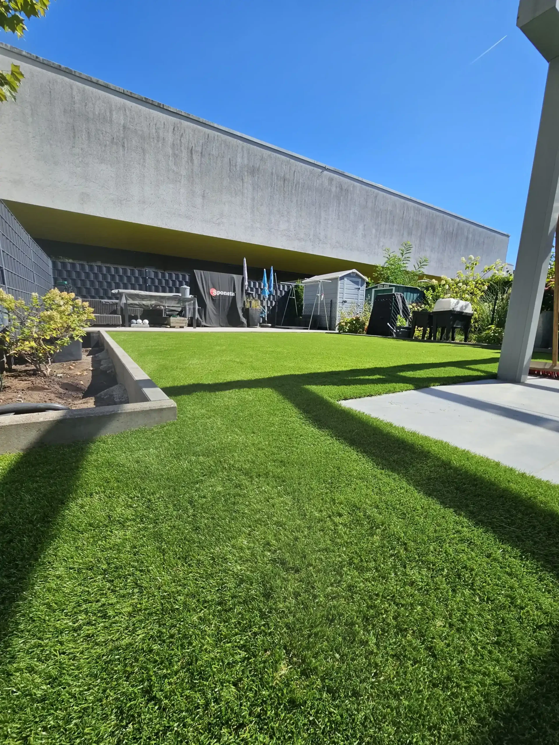 Luxuriöser Außenbereich mit frischem Kunstrasen neben einem Pool, ideal für Projekte zum Kunstrasen verlegen.